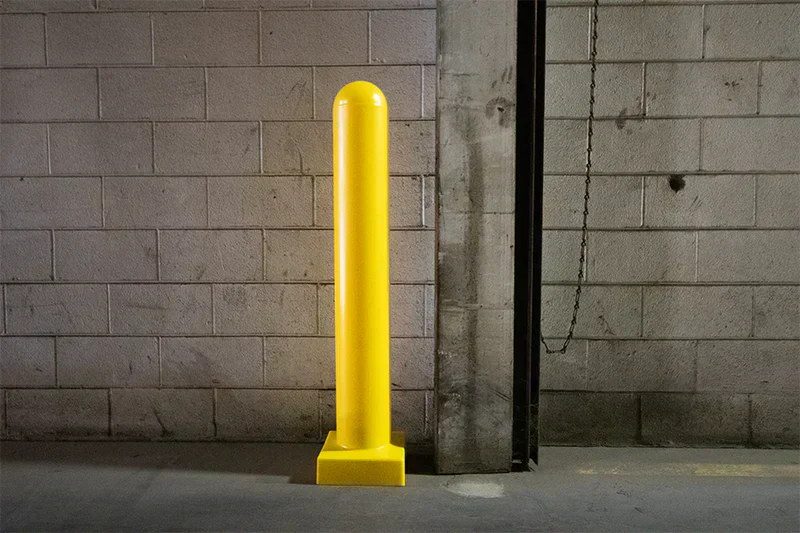 Steel bollard posts with yellow bollard covers improving visibility in parking lot 