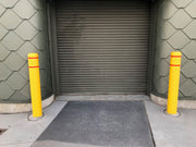 Flat Top Bollard Covers in yellow with red reflective tape at an entrance