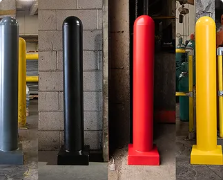 Four bollards in different colors (silver, black, red, yellow) against a concrete wall.