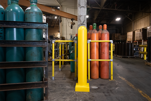 Storage area with blue and orange gas cylinders on metal racks in a warehouse.